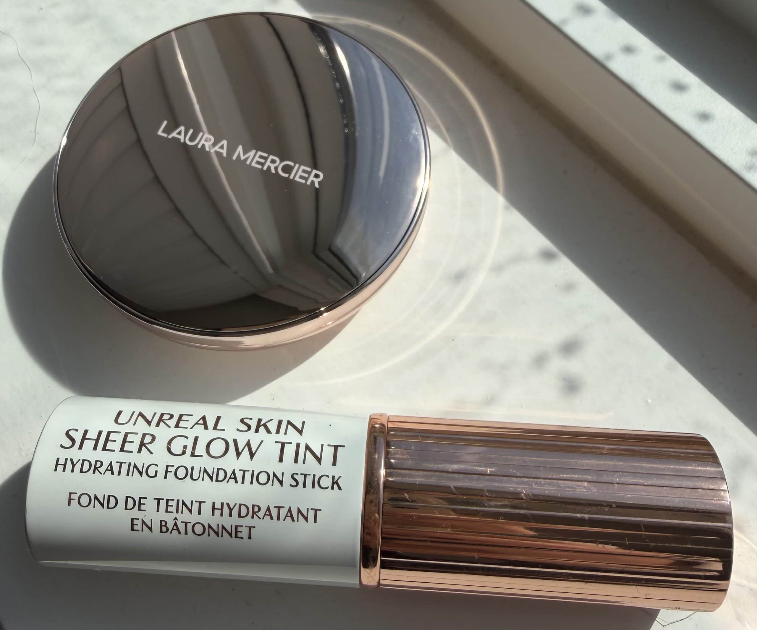 LAURA MERCIER TINTED BLUR BALM AND THE CHARLOTTE TILBURU SKIN TINT STICK ON A WINDOW SILL